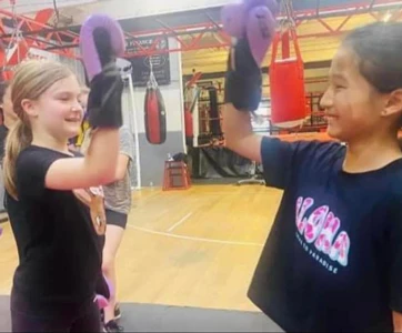 Girls practising pad work with a Revenge coach